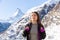 Female backpacker admiring mountain scenery while traveling in winter Swiss Alps