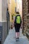 Female backpacker exploring narrow streets of medieval town.