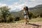 Female backpacker travelling down the road in hills