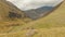 Female backpacker woman standing on rock and admiring beautiful valley. KAzbegi hiking adventure