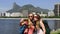 Female backpackers tourists with smartphone in Rio de Janeiro with Christ the Redeemer in background.