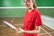 Female badminton player holding racket strings to check condition