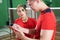 Female badminton player listening to coach's instructions while practicing