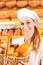 Female baker in bakery selling bread by basket