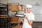 Female Baker Carrying Dough Tray At Bakery