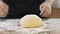 Female baker cook bread, close up hands kneading raw dough ball on wooden table