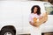 Female Baker Delivering Bread Standing In Front Of Van