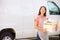 Female Baker Delivering Cakes Standing In Front Of Van