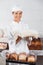 Female Baker Holding Bread Slices In Bakery