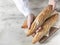 Female baker holds fresh baked French baguette. Homemade sourdough bread. Homemade food. Food preparation