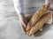 Female baker holds fresh baked French baguette. Homemade sourdough bread. Homemade food. Food preparation