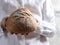 Female baker holds home made artisan organic bread fresh from the oven. Homemade sourdough bread. Homemade food