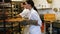 Female baker removing baked michetta from baking trolley