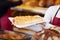 Female Bakery Worker Holding Tray Of Sweet Bread