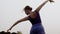 Female ballerina rehearses dance background sky, back view. Dancer trains outdoors. Woman dances classical dance in