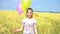 Female with balloons having fun in field in slow motion