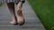 female bare feet, closeup, woman is walking over wooden path at summer