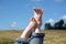 Female bare feet with red nails against summer landscape