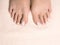 Female bare feet, toes with white pedicure on ivory terry towel, close up.