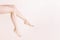 Female bare legs raise, On a beige background. Beauty salon,