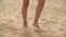 Female barefoot feet walking on sand on summer beach. Close up barefoot girl legs walking on dry sandy sea beach.