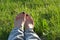 Female barefoot resting on the green grass background