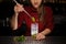 Female bartender adding a leaf of fresh mint to a cane sugar wit