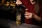 Female bartender filling a liqour to the measuring pile