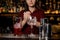 Female bartender making final actions with the cocktail