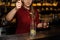 Female bartender pourring into a glass a spoon of cane sugar