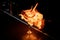 Female bartender serving cocktail in the glass in the fire around