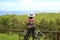 Female biker admiring the scenic Pacific ocean from Rano Kau volcano on Easter Island, Chile