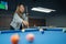 female billiard player pointing on the billiard balls while playing billiard