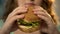 Female biting fast food burger closeup, unhealthy nutrition and overeating