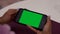 Female black hands uses smartphone with green screen chroma key. Few types of motion - scrolling, tapping, zoom in and