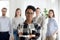 Female black millennial employee standing foreground arms crosse