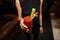 Female in the black shirt holding a glass of alcoholic cocktail Bloody Mary