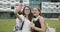 Female bloggers filming a selfie video in modern city background. Outdoor portrait of pretty happy girls making video