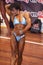 Female bodybuilder in abdominals and thighs pose and blue bikini