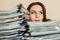 Female bookkeeper with large stacks of documents