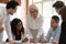 Female boss explaining corporate paperwork at briefing with multiracial staff