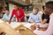 Female Boss Leading Meeting Of Architects Sitting At Table