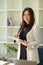 Female boss standing and holding a business clipboard in office