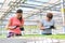 Female botanists examining over seedlings in greenhouse