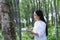 Female botanists in white coat at the forest.Young asian scientist woman looking at the bark of the rubber tree and make notes to