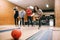 Female bowler throws ball on lane, strike shot