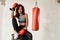 Female boxer sitting on barrel in training room