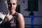 Female Boxer wearing gloves posing in boxing studio