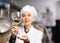 Female brewer showing natural granulated hops in glass