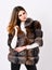 Female brown fur coat. Fur store model posing in soft fluffy warm coat. Pretty fashionista. Fur fashion concept. Woman